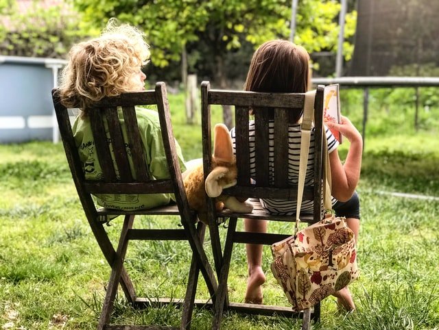 Deux enfants sur des chaises de jardin