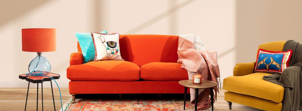 Orange Sazy sofa with decorative throw cushions in a living room set up