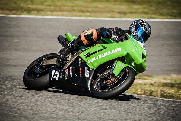 Moto verte sur circuit dans un virage