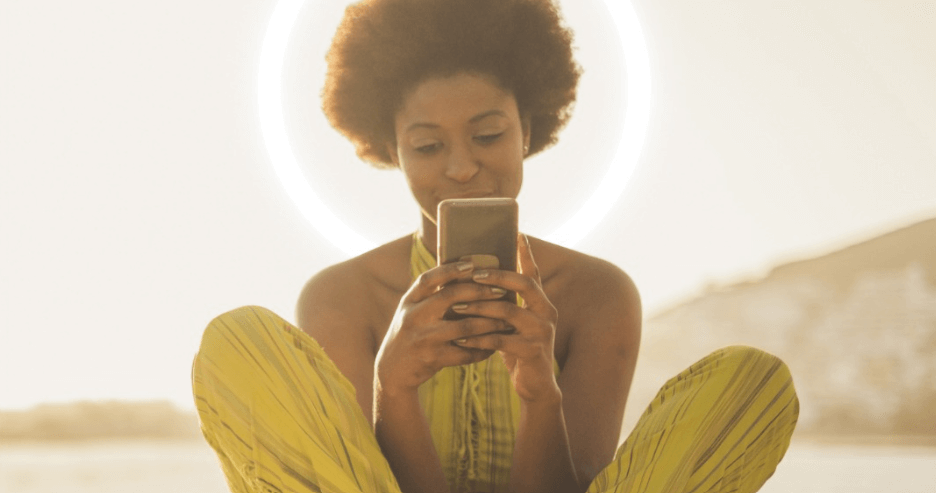 Sell Ur deals banner showing a woman in yellow dress crouching down with smartphone held up to her face