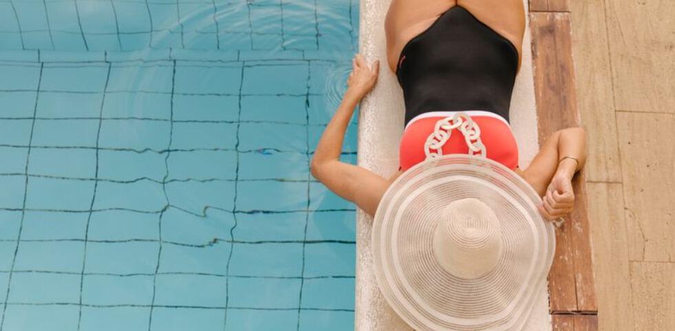 Sercotel savings page banner. Image shows a woman in swimsuit wearing a large hat relaxing next to a pool