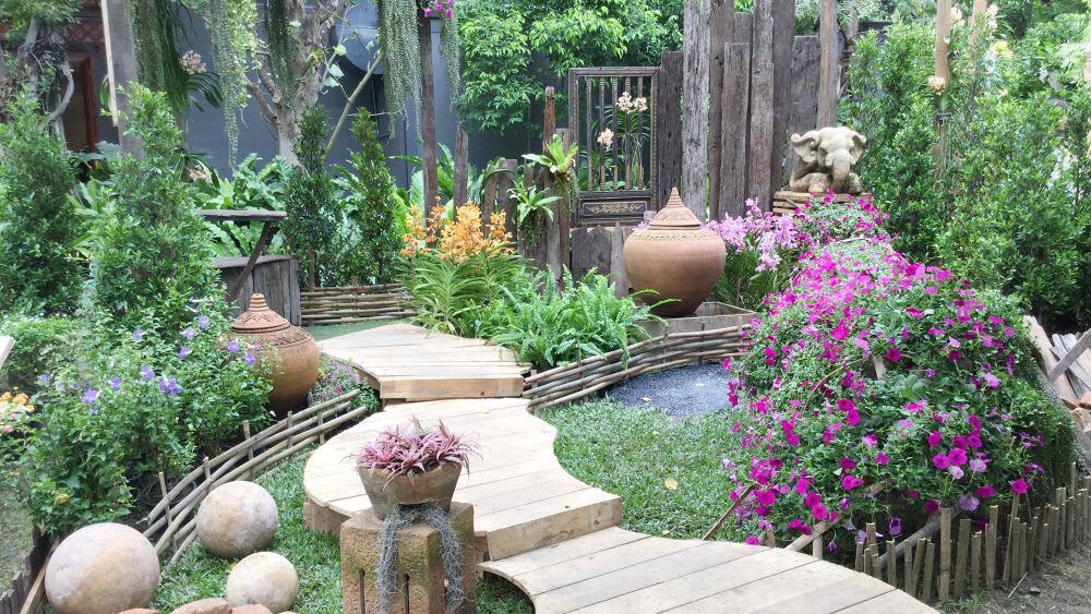 Small garden with a waving path, small pond and randomly placed terracotta garden ornaments