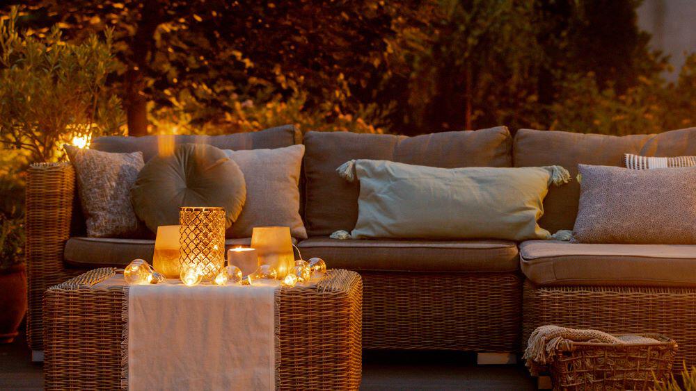 Outdoor sofa at night, lit by solar lights on an outdoor table