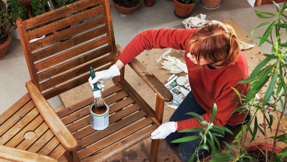 Aerial view of a woman varnishing a wood chair