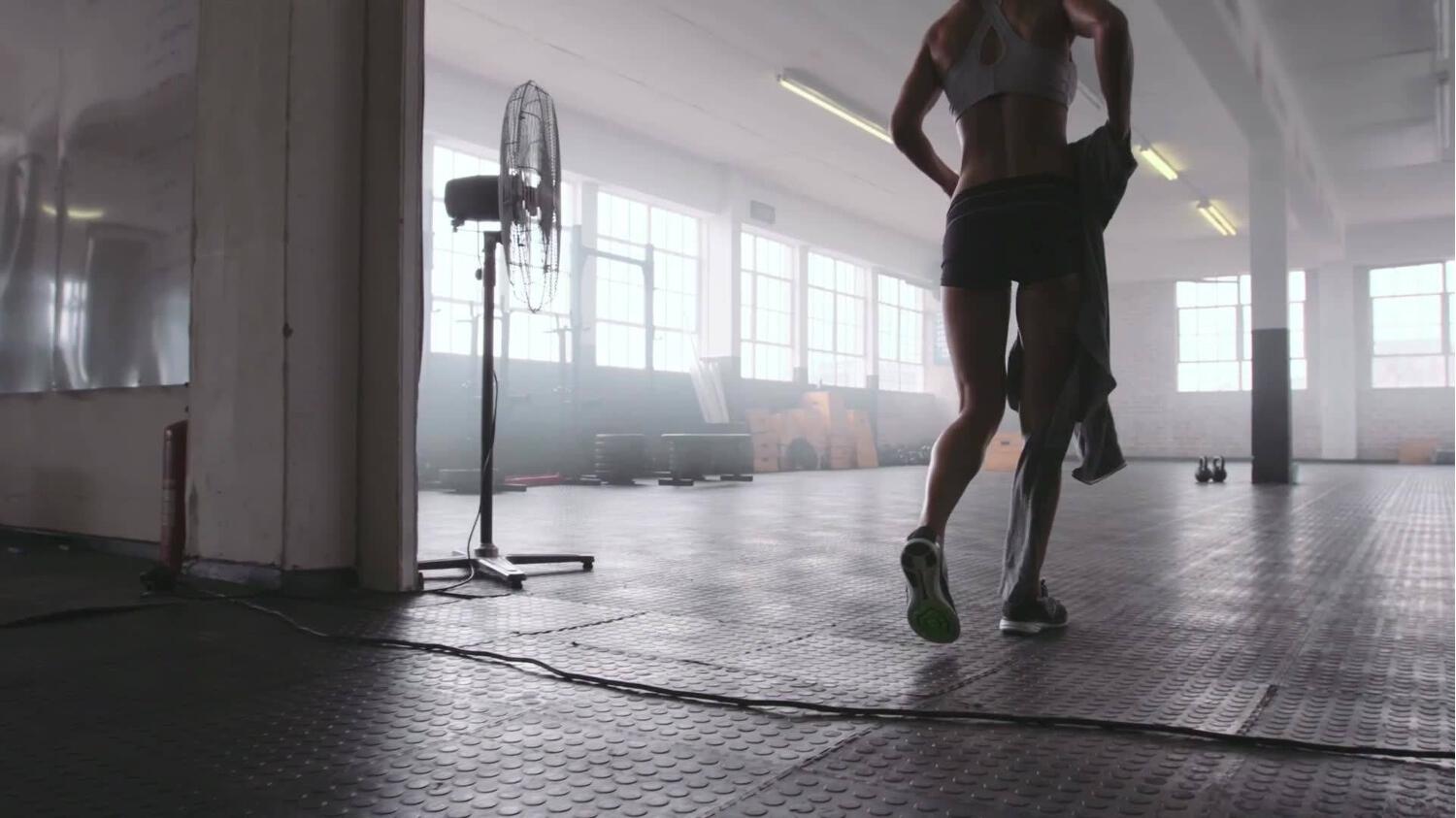 une sportive de dos dans une salle de sport