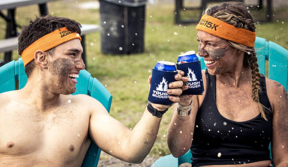 Teilnehmer genießen einen Drink nach einem Tough Mudder Event