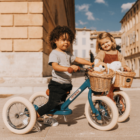 Deux enfants sur des tricycles en bois Jeujouet