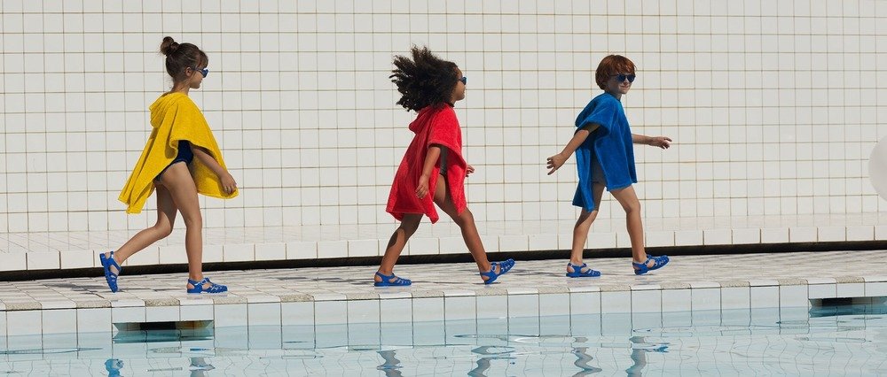 Trois enfants avec des ponchos de bain Petit Bateau 