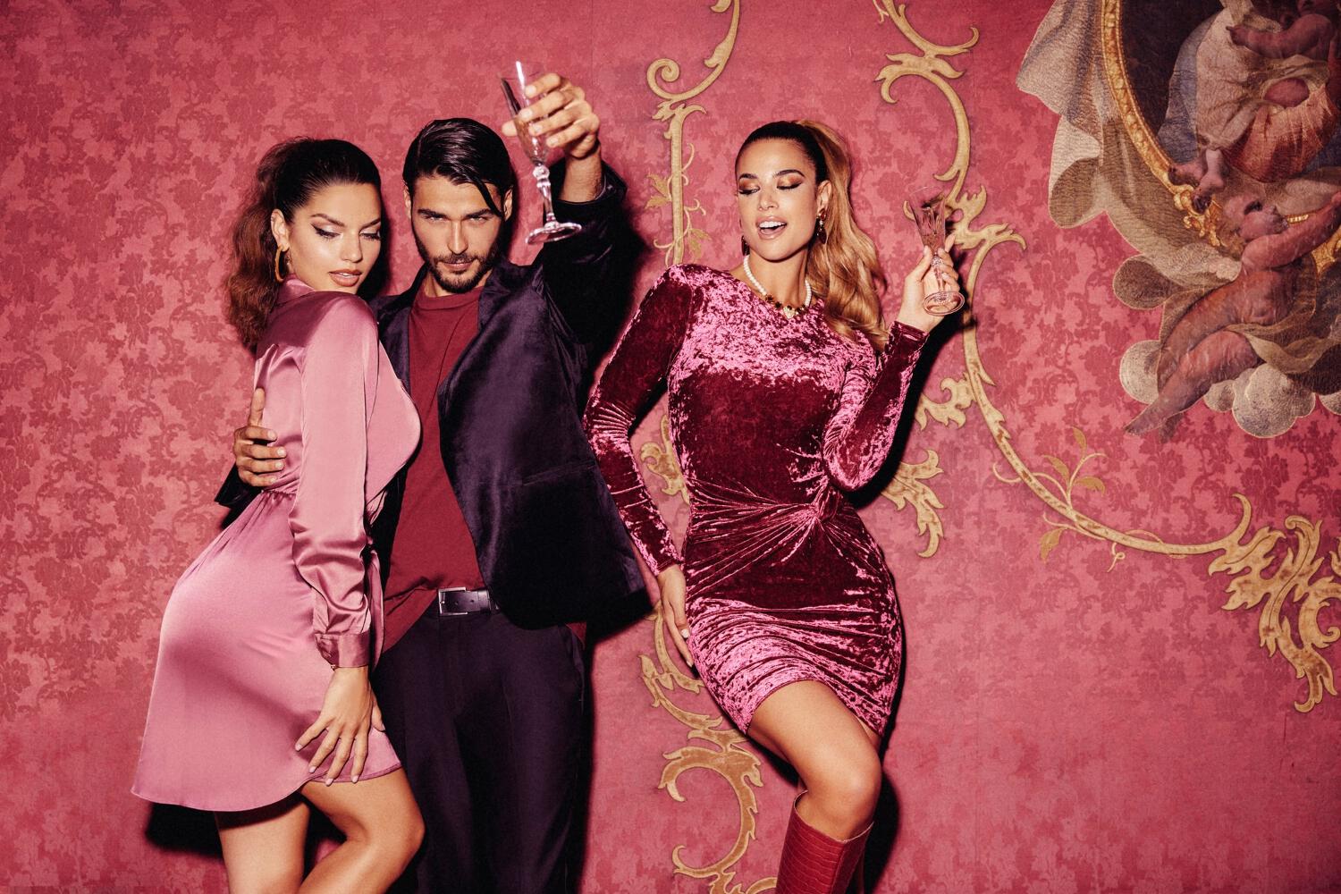 trois mannequins Guess sur fond rose en tenue de fête