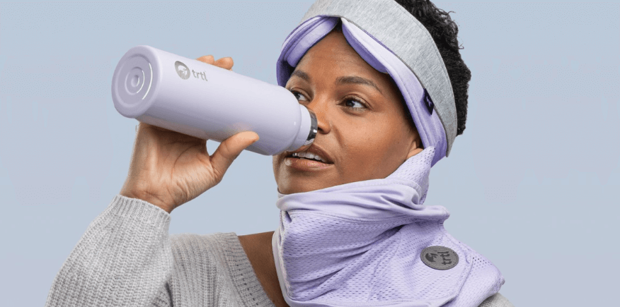 Trtl Travel deals banner featuring a woman wearing a lilac sleep mask and holding a branded water bottle to her mouth