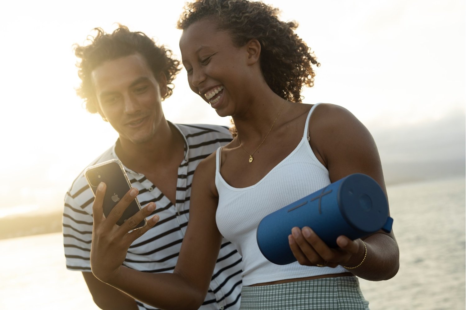 Couple sur la plage avec une enceinte Ultimate Ears bleue