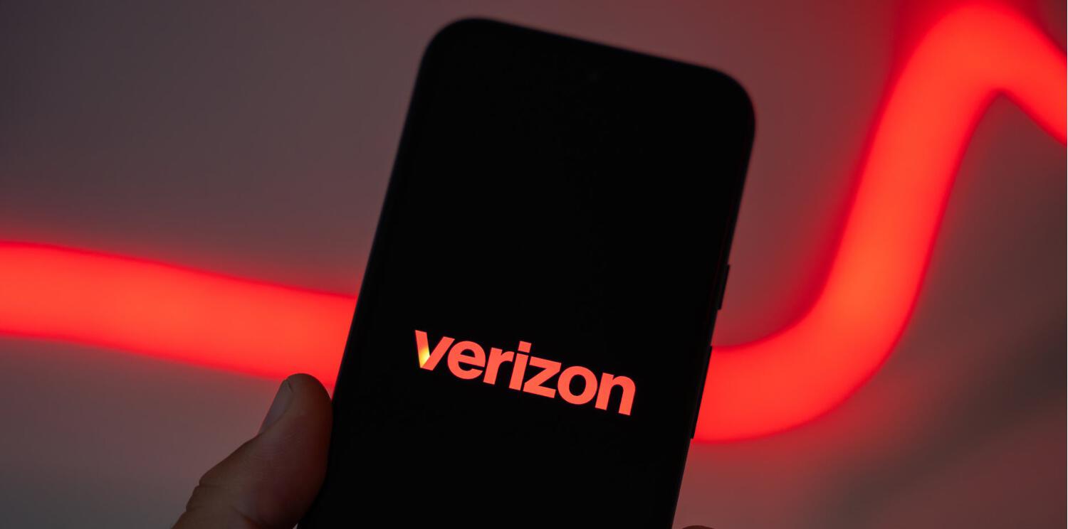 Hand holding phone with Verizon logo on screen