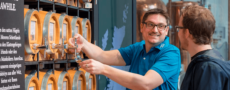 Mann wird in einem Vom Fass Geschäft zu Ölen und anderen Produkten beraten