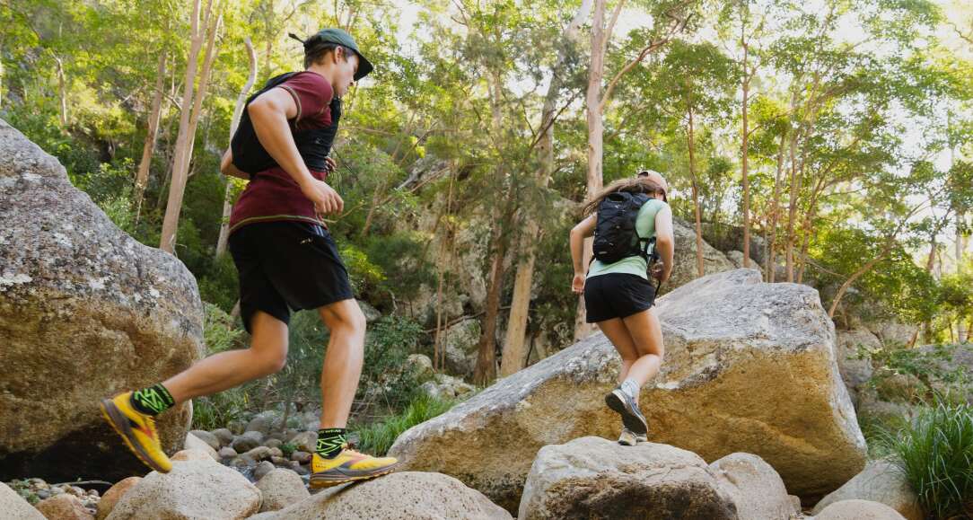 Wilderness Wear deals page banner showing a man and woman running across some rocks wearing athletic apparel and backpacks