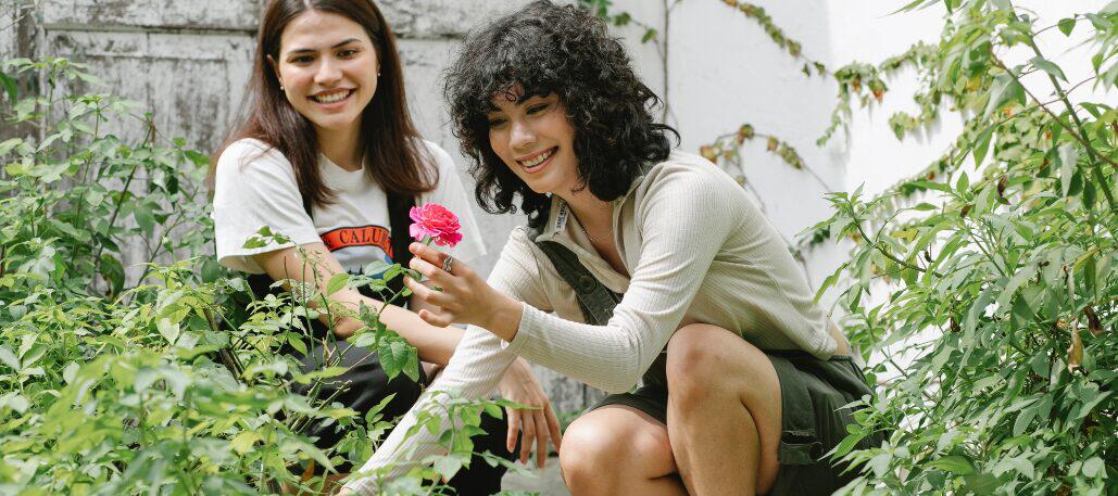 women gardening, with one holding a flower