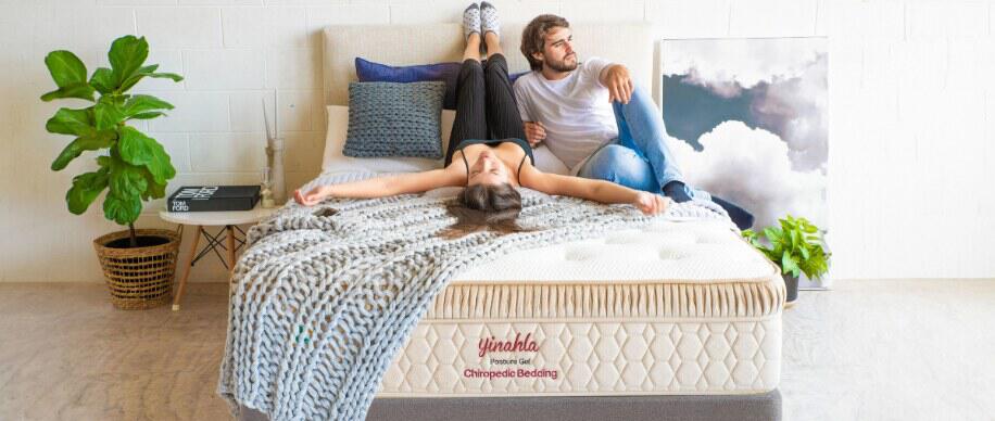 Yinahla deals page image showing a man and woman lounging on an unmade bed displaying the mattress brand logo